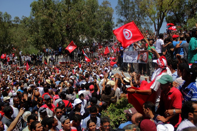 La foule scande l’hymne national après que le cercueil soit arrivé. Crédit image : Amine Boufaied - www.nawaat.org